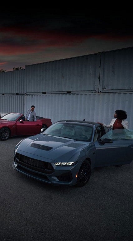 Two people exiting their parked 2024 Ford Mustang® coupe and convertible | Bob Poynter Ford, Inc. in Seymour IN